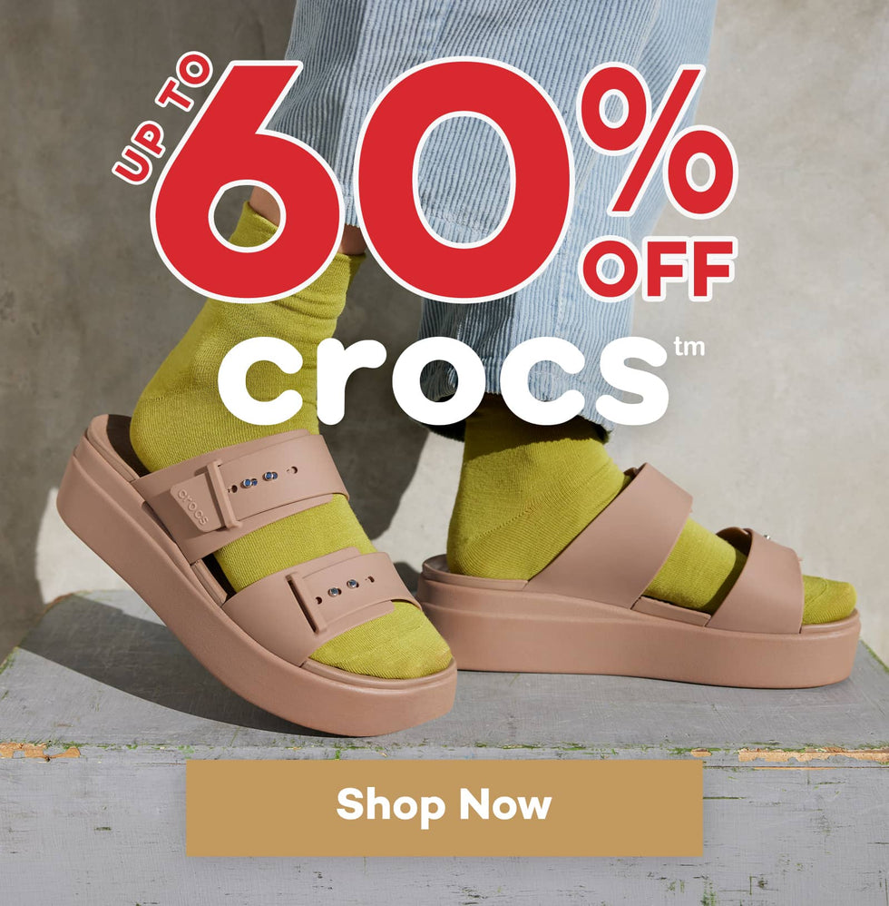 Advertisement for Crocs sale with up to 60% off and a person wearing Crocs Brooklyn Buckle sandals.
