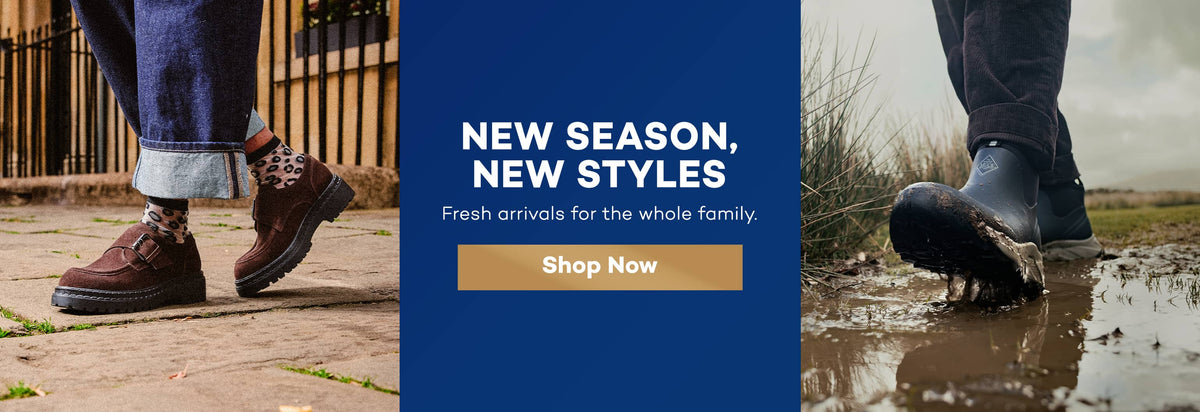 A promotional banner featuring two lifestyle photos of footwear: on the left, a person wearing brown lace-up boots with patterned socks and blue jeans standing on a stone path; on the right, a person wearing dark rubber boots stepping into a muddy puddle. A large blue central panel reads 'NEW SEASON, NEW STYLES' with 'Fresh arrivals for the whole family.